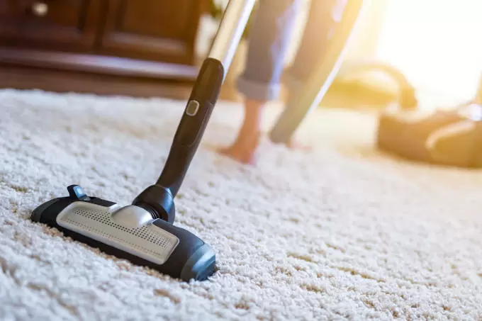 Young woman using a vacuum cleaner